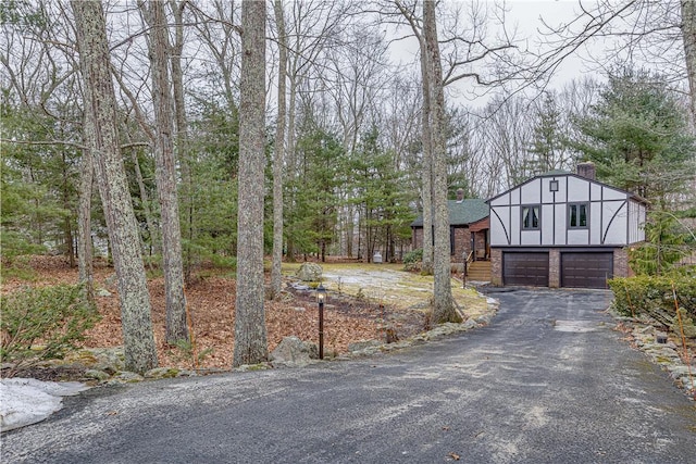 exterior space featuring a garage, driveway, and stucco siding