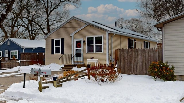 bungalow featuring entry steps, fence, and solar panels