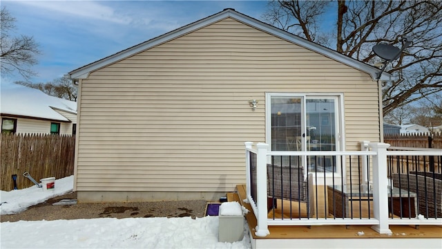 view of snow covered exterior with fence