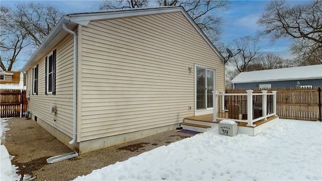 view of snow covered exterior with fence