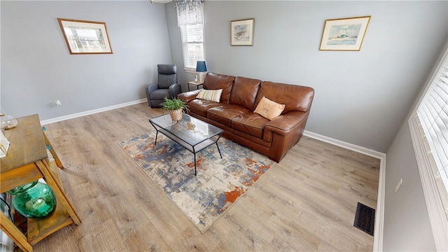 living area featuring wood finished floors, visible vents, and baseboards