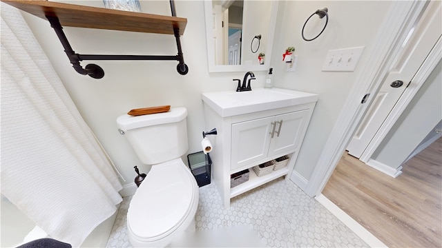 full bath featuring toilet, baseboards, and vanity