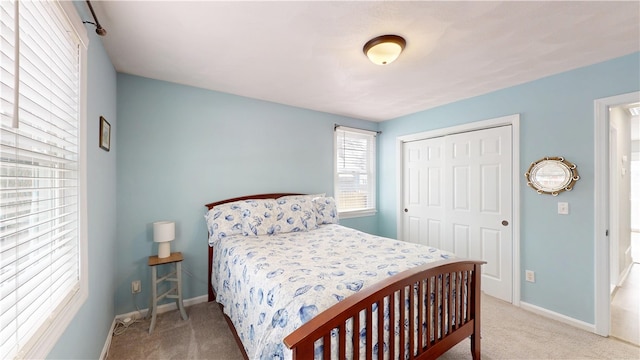 carpeted bedroom with a closet and baseboards