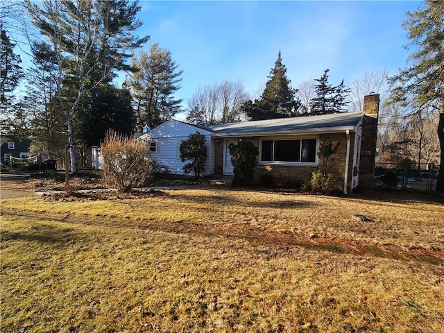 single story home with a front yard and a chimney