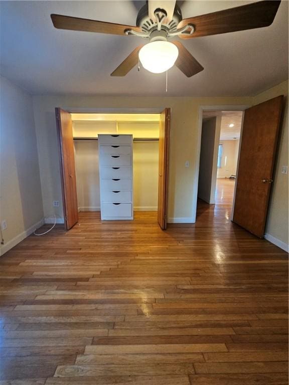 unfurnished bedroom featuring a closet, baseboards, and wood finished floors