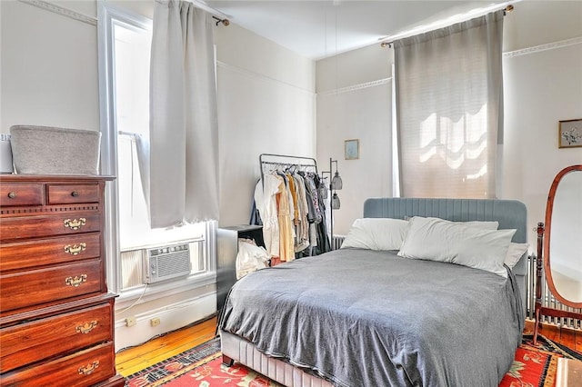 bedroom featuring cooling unit and wood finished floors