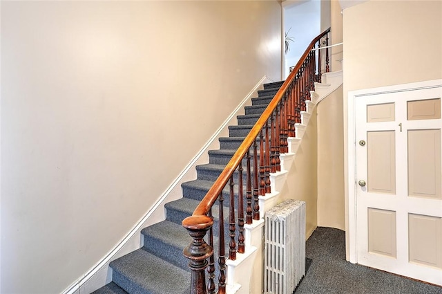 stairs with baseboards, carpet, and radiator