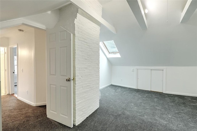 additional living space featuring carpet floors, vaulted ceiling with skylight, and baseboards