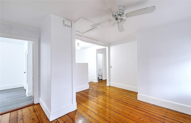 spare room featuring light wood-style flooring, baseboards, and ceiling fan