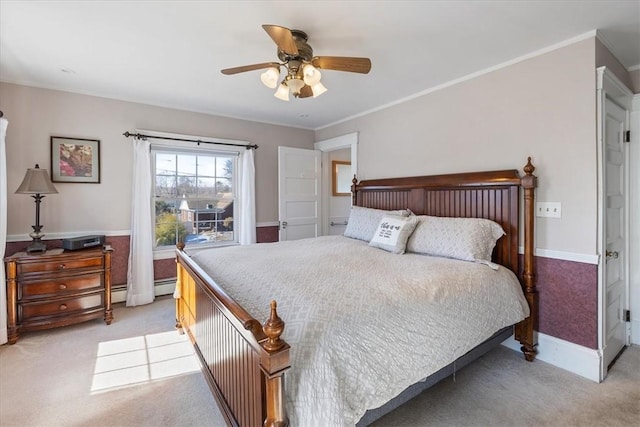 bedroom with a wainscoted wall, crown molding, light colored carpet, ceiling fan, and baseboards