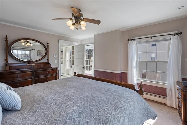 carpeted bedroom featuring a baseboard radiator, ceiling fan, and crown molding