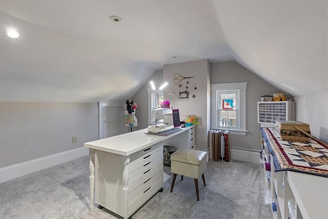 office area featuring lofted ceiling, light carpet, and baseboards