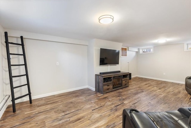 living room featuring a baseboard radiator, baseboards, and wood finished floors