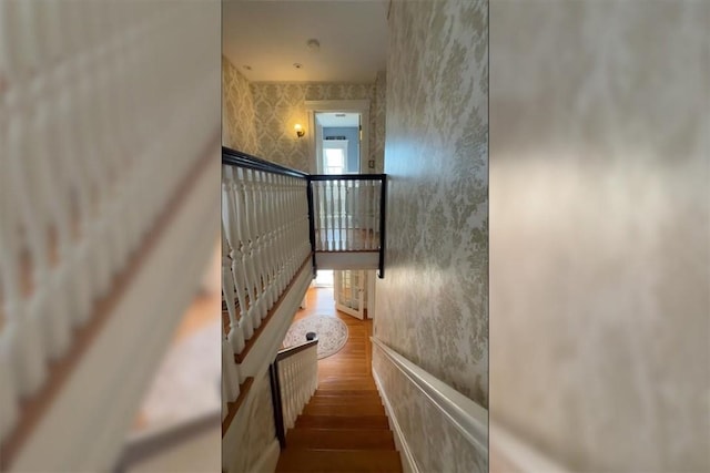 staircase featuring radiator, wood finished floors, and wallpapered walls