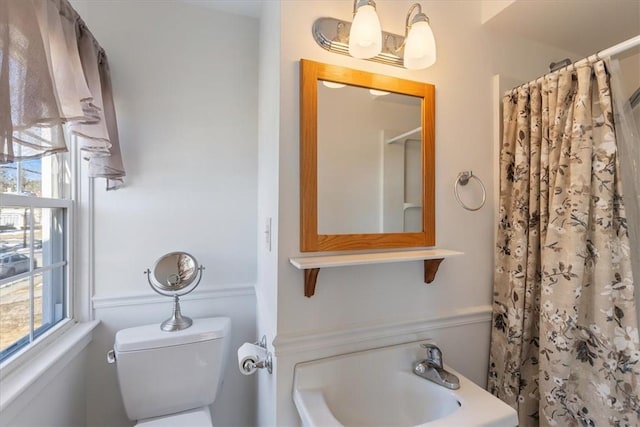 bathroom featuring curtained shower and toilet