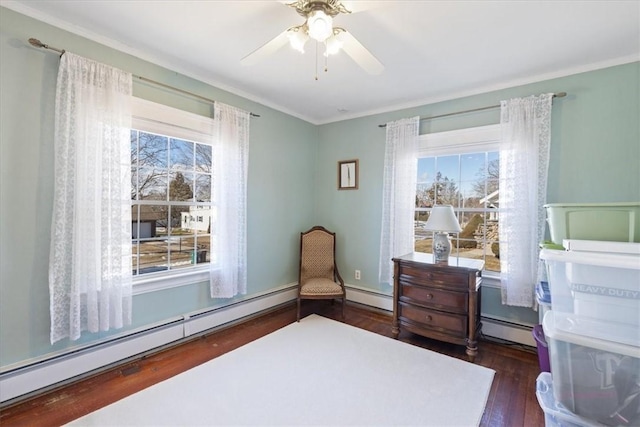 bedroom featuring a baseboard heating unit, a ceiling fan, and wood finished floors