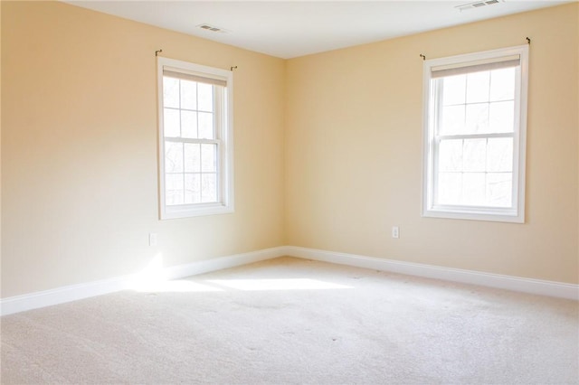 carpeted spare room with visible vents and baseboards