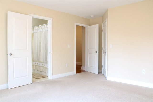 unfurnished bedroom featuring carpet flooring, connected bathroom, and baseboards