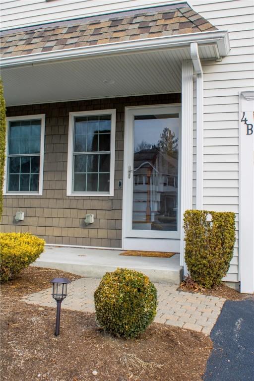 entrance to property with roof with shingles