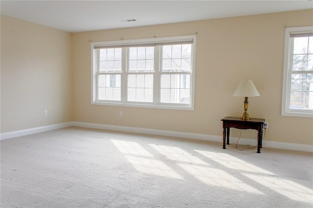 unfurnished room featuring baseboards, visible vents, and light colored carpet