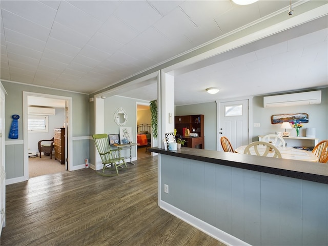 interior space with baseboards, dark countertops, dark wood-style flooring, a wall mounted air conditioner, and an AC wall unit