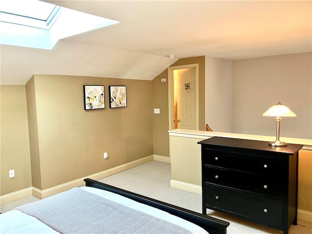 bedroom with light carpet, lofted ceiling with skylight, and baseboards