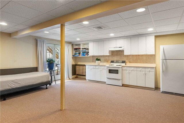 kitchen featuring tasteful backsplash, light countertops, visible vents, white cabinetry, and white appliances