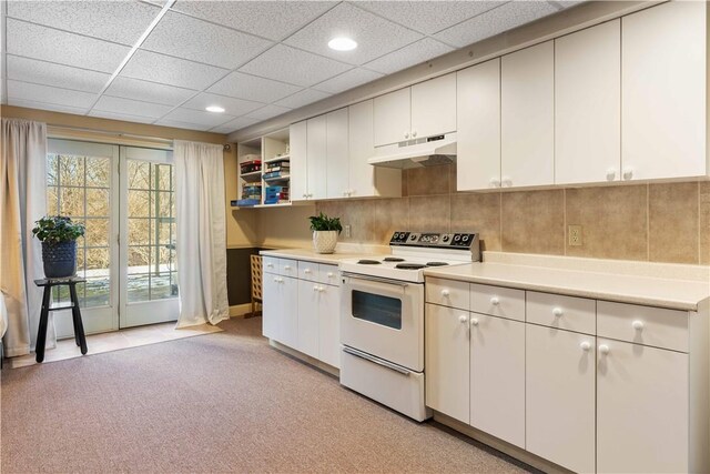 kitchen featuring light countertops, under cabinet range hood, a drop ceiling, and white electric range oven