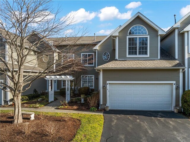 view of front of house featuring a garage, aphalt driveway, a shingled roof, and a pergola