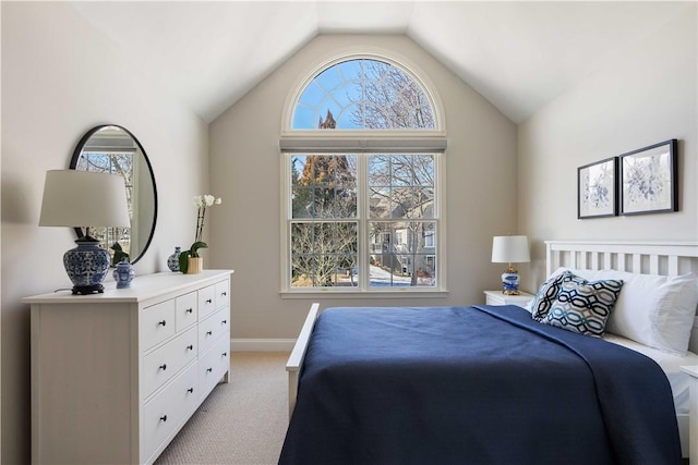 bedroom featuring light carpet, baseboards, and lofted ceiling