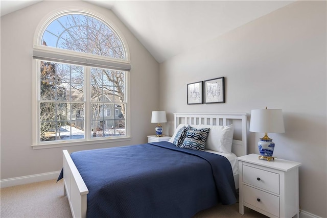 bedroom with baseboards, vaulted ceiling, and light colored carpet