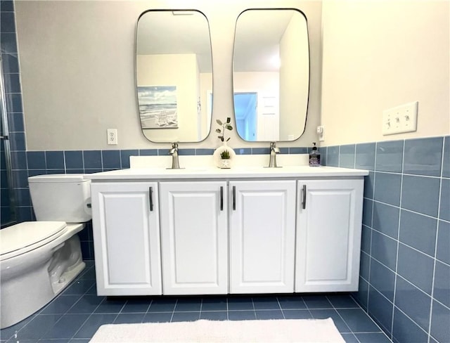 full bath featuring tile patterned flooring, tile walls, toilet, and double vanity