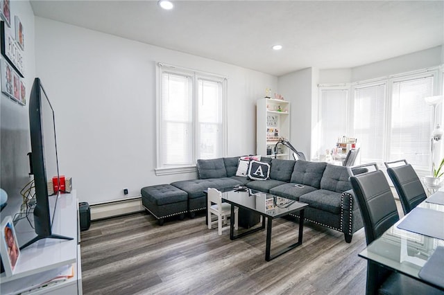 living room featuring a baseboard heating unit, wood finished floors, and recessed lighting