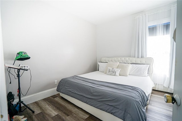 bedroom featuring wood finished floors and baseboards