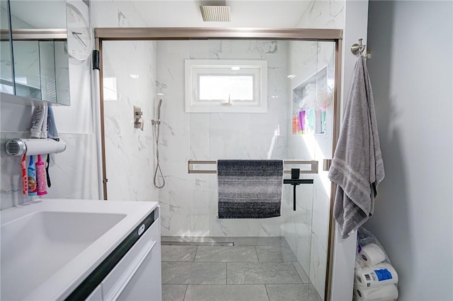 bathroom featuring tile walls, visible vents, vanity, and a marble finish shower