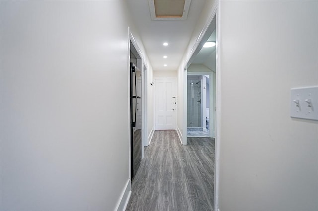 corridor featuring recessed lighting, wood finished floors, and baseboards