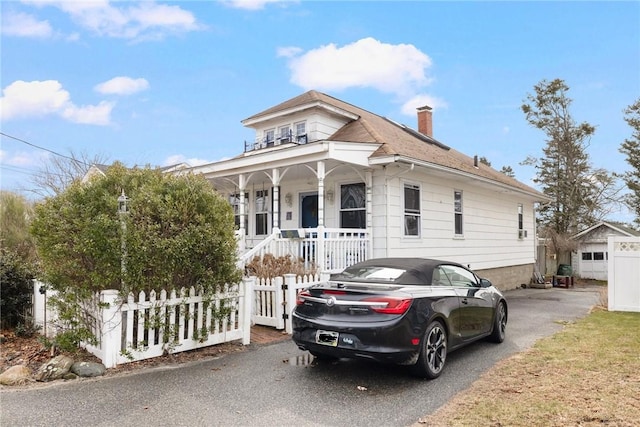 bungalow with a fenced front yard, a chimney, and a porch