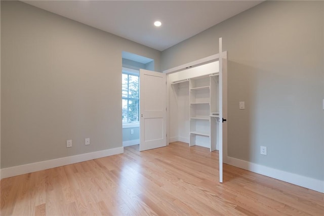 unfurnished bedroom with light wood-style floors, a closet, and baseboards