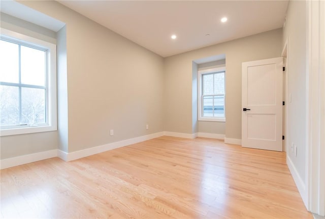 spare room with light wood finished floors, baseboards, and recessed lighting