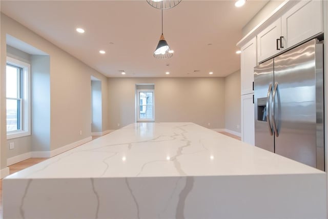 kitchen featuring baseboards, hanging light fixtures, white cabinetry, stainless steel refrigerator with ice dispenser, and recessed lighting