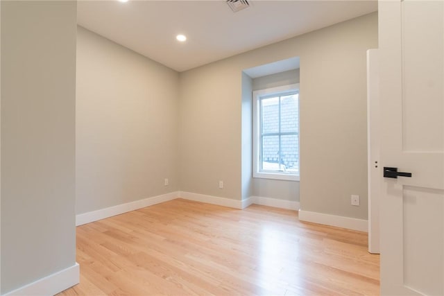 unfurnished room with light wood-type flooring, visible vents, baseboards, and recessed lighting