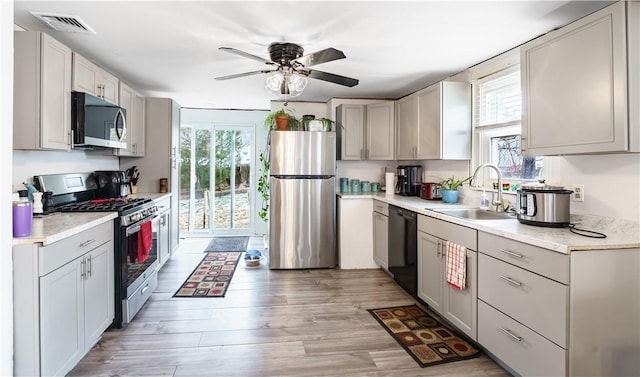 kitchen with appliances with stainless steel finishes, plenty of natural light, visible vents, and a sink