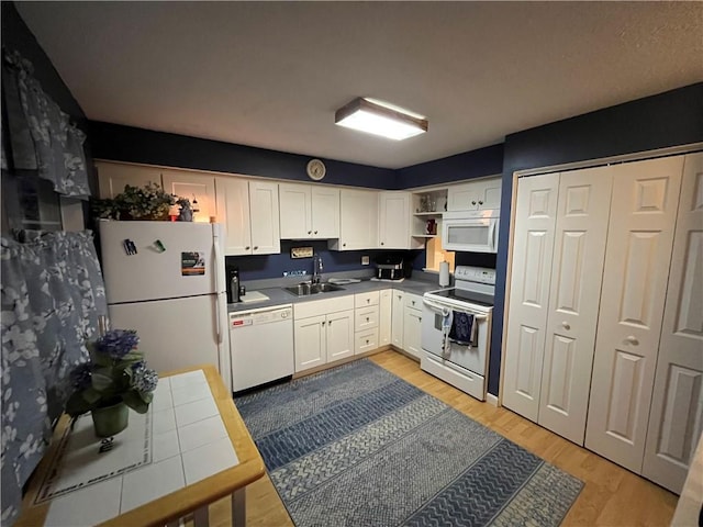 kitchen with open shelves, white appliances, a sink, and white cabinets