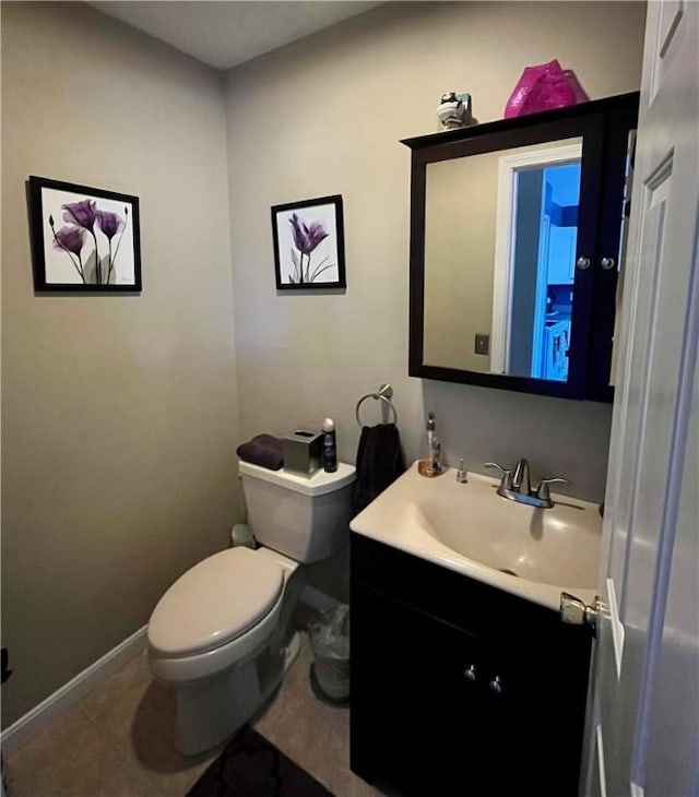 bathroom featuring toilet, tile patterned flooring, baseboards, and vanity