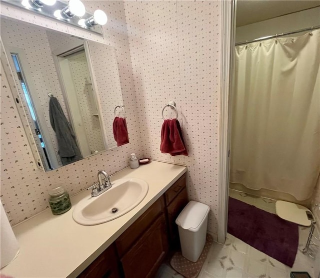 full bath featuring toilet, vanity, and wallpapered walls