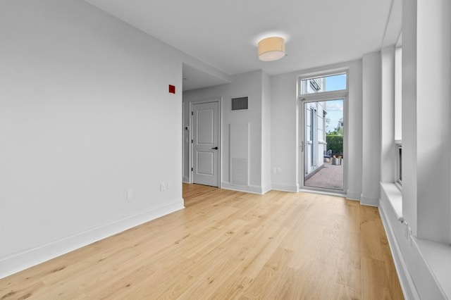 interior space with light wood-style floors, visible vents, and baseboards