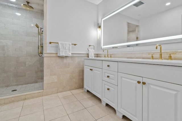 full bath featuring a sink, tile walls, tiled shower, tile patterned floors, and double vanity