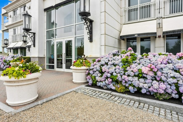 entrance to property featuring french doors and stucco siding