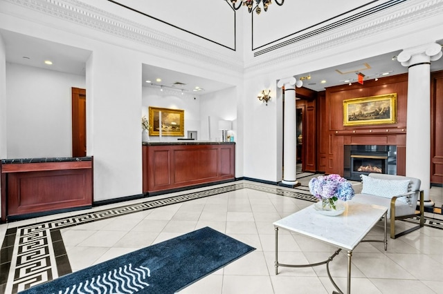 welcome area featuring a glass covered fireplace and decorative columns