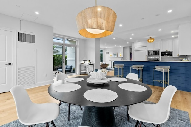 dining space with light wood-type flooring, baseboards, visible vents, and recessed lighting